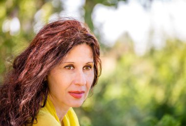 zarif ve göz alıcı menopozal kadın olgun cilt ile yüzünde yaşlanma belirtileri gösteren yeşil bir parkta gülümsüyor