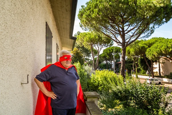 Sénior posando como super-herói com cloack vermelho e máscara — Fotografia de Stock