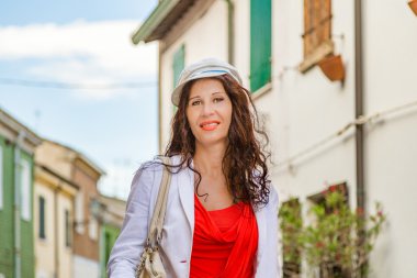 alışveriş çantası ile orta yaşlı kadın bir balıkçı köyünde yürüyüş