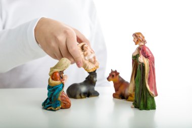 Bir çocuk basit bir Ch Tamamlanıyor bebek İsa heykeli koymak