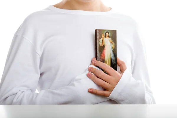 Menino caucasiano segurando ícone de Jesus Misericordioso — Fotografia de Stock