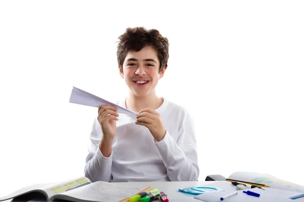 Beyaz çocuk önünde oturan bir kağıt uçak ile oynarken — Stok fotoğraf