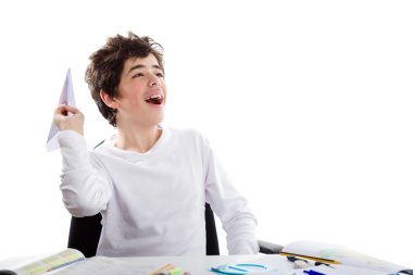 Latin çocuk ev önünde oturan bir kağıt uçak ile oynarken