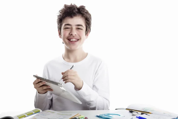 Happy boy writing on tablet while doing homework — Stock Photo, Image