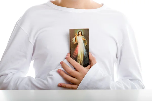 Menino hispânico segurando ícone de Jesus Misericordioso — Fotografia de Stock