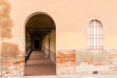 Yuvarlak cloister giriş ve kırmızı demir ızgara penceresiyle