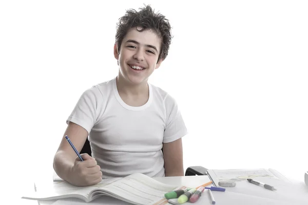 Teenager boy on homework smiling and writing — Stock Photo, Image