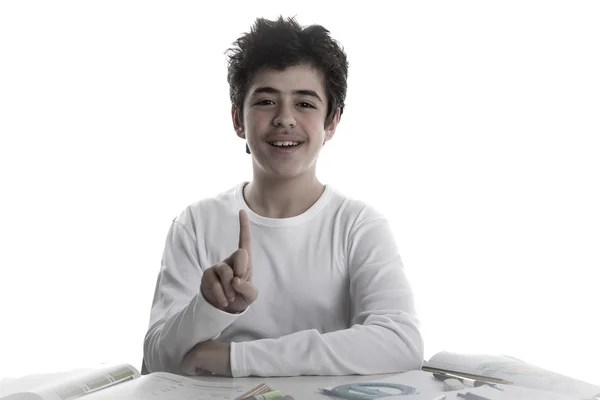 Adolescente menino em trabalhos de casa sorrindo e mostrando número 1 — Fotografia de Stock