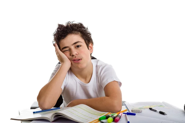 Tired boy holds his face in front of homework — Stock Photo, Image
