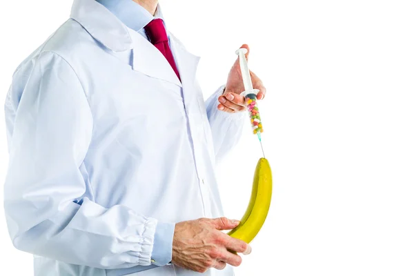 Doutor em casaco branco fazendo uma injeção em uma banana — Fotografia de Stock