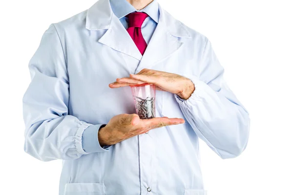 Orvos holding acél csavarok egy pohár fehér kabát — Stock Fotó