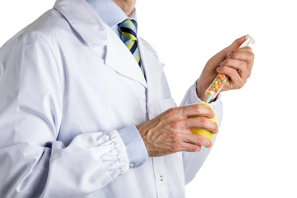 Homem de casaco branco médico faz uma injeção para maçã amarela — Fotografia de Stock