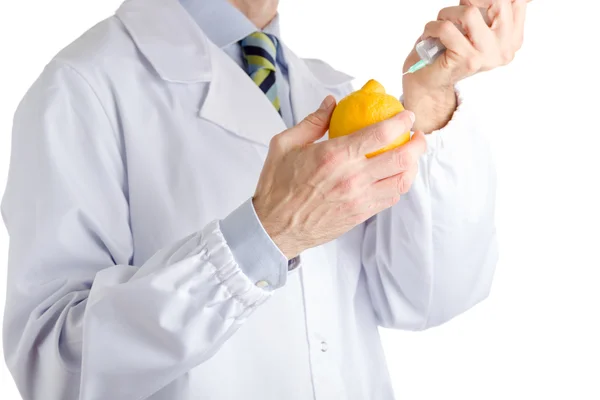 Homem de casaco branco médico faz uma injeção no limão amarelo — Fotografia de Stock