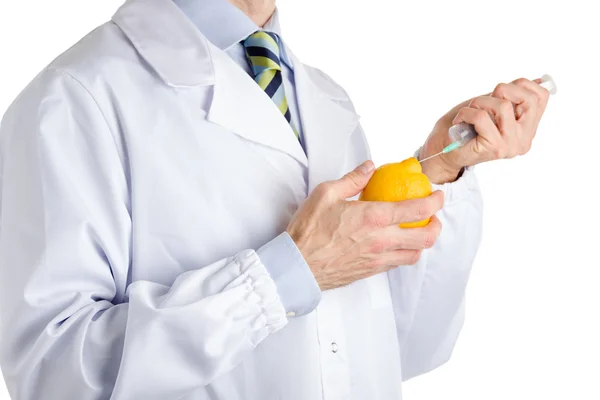 Férfi orvosi fehér kabátot teszi egy injekciót sárga citrom — Stock Fotó