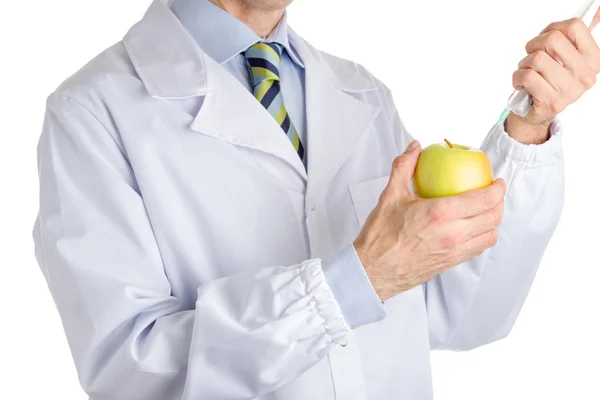 Ο άνθρωπος στην ιατρική άσπρο παλτό κάνει μια ένεση στο κίτρινο μήλο — Φωτογραφία Αρχείου