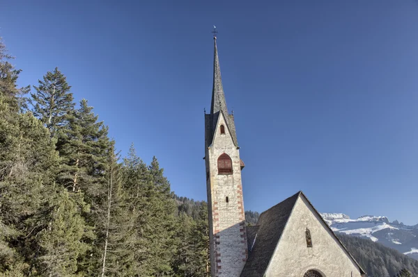 Church of St. Jacob overlooking pine forests and snow-capped pea — Stock Photo, Image
