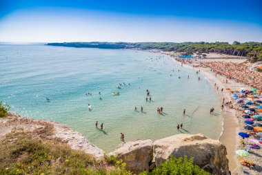 İtalya'da Puglia Salento kıyısında kayalık koy yakınlarındaki koyda plaj tesisleri
