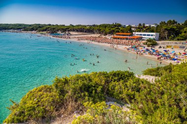 İtalya'da Puglia Salento kıyısında kayalık koy yakınlarındaki koyda plaj tesisleri