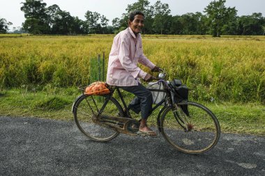 Majuli Adası, Hindistan - Kasım 2020: 19 Kasım 2020 'de Assam, Hindistan' da bisiklet süren bir adam.