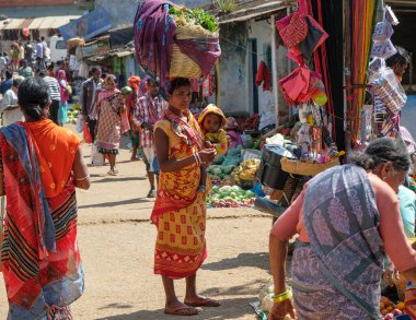 Koraput, Hindistan - Şubat 2021: Kondh kabilesinden Adivasi kadın çocuğu ile 21 Şubat 2021 'de Odisha, Hindistan' da Koraput pazarında sebze alışverişi yaptı..