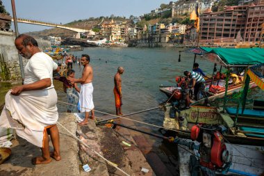 Omkareshwar, Hindistan - Mart 2021: 20 Mart 2021 'de Hindistan' ın Madhya Pradesh kentinde Narmada Nehri 'nde yıkanan insanlar.
