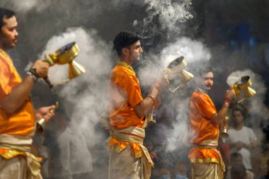 Varanasi, Hindistan - Nisan 2021: Hindistan 'ın Uttar Pradesh şehrinde 5 Nisan 2021 tarihinde Dashashwamedh Ghat' ta Ganga Aarti dini ayinini gerçekleştiren Hindu rahipler.