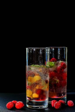 Summer drink in glasses on black background. Fresh raspberry lemonade