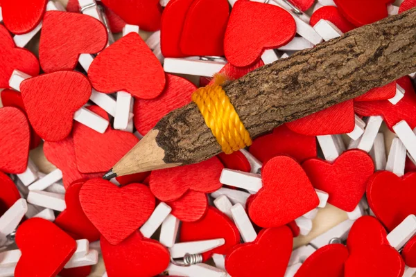Pencil on heart shaped paper clip background. — Stock Photo, Image
