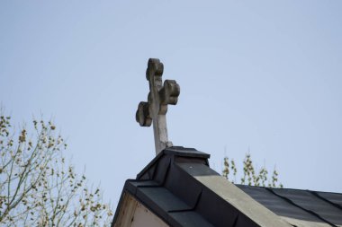 Kilisenin çatısı, dini binanın tepesinde büyük metal haç, mavi gökyüzüne karşı Hıristiyan kilisesi.