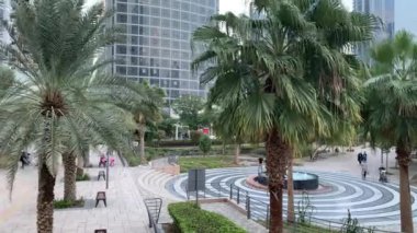 Dubai / BAE - 08 Kasım 2020: Jumeirah Lakes Kuleleri 'nin lüks semti ve çeşmeli park manzarası. JLT 'de yaşayan bir sürü yürüyen insan var. Dubai Halk Parkı. Zaman aşımı