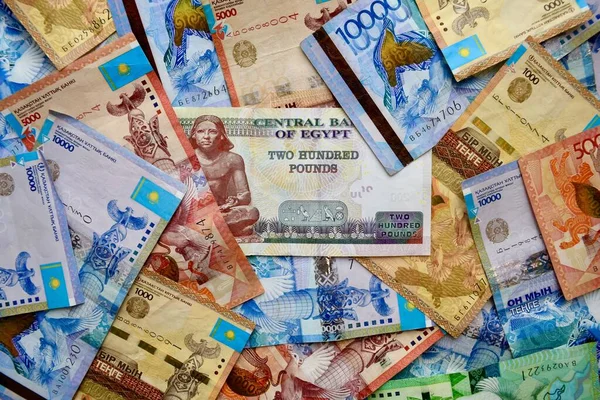 Billetes nacionales de Egipto en la parte superior de la moneda nacional de Kazajstán, vista superior de los billetes de tenge mixtos. Papel moneda Kz. Tipo de cambio Tenge y libra egipcia. KZT y EGP — Foto de Stock