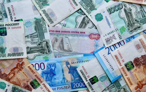 Billetes de los EAU en la parte superior de la moneda nacional rusa, vista superior de los billetes de rublo mixtos. Papel moneda ruso. Tipo de cambio Rublo y Dirham. Frotar y AED — Foto de Stock