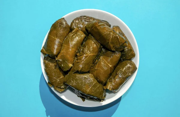 Feuilles de raisin farcies dans un bol blanc sur fond bleu. Célèbre Moyen-Orient traditionnel, cuisine turque et asiatique. Dolma ! — Photo