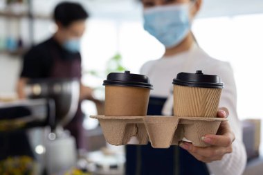 Yakın plan barista müşteriye bir fincan kahve tutuyor..