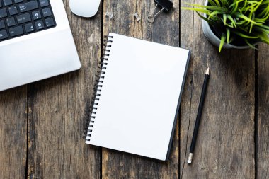 Tahta masadaki bilgisayarlı boş defter, üst görünüm