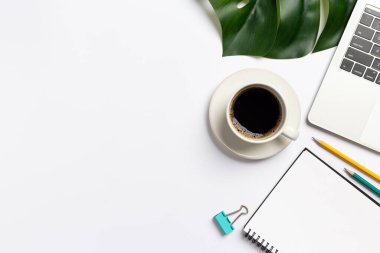 Üst manzara, çalışma masası, beyaz arka planda kahve ve ofis malzemeleri.