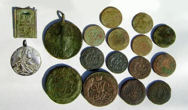 Russian copper coins of the 18th century and pendants on a light background