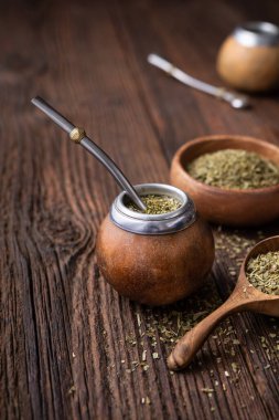 Sağlıklı karıştırılmış içecek, ahşap zemin üzerinde bombilla bulunan bir su kabağında klasik Yerba Mate çayı.