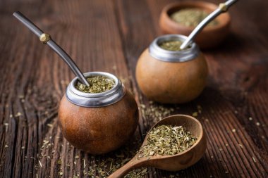 Sağlıklı karıştırılmış içecek, ahşap arka planda mobilla ile kabak içinde klasik Yerba Mate çayı.