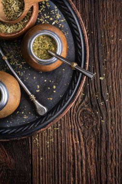 Sağlıklı karıştırılmış içecek, ahşap zemin üzerinde bombilla bulunan bir su kabağında klasik Yerba Mate çayı.