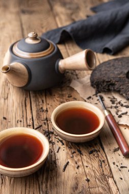 Ahşap zemin üzerinde seramik bardaklarda tıbbi Pu-erh çayı
