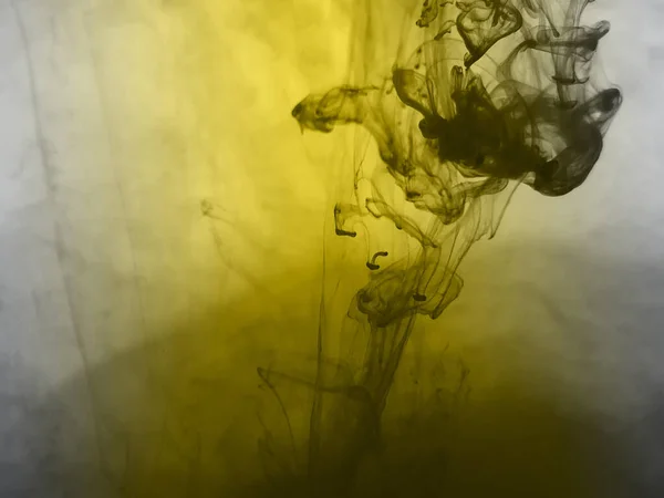 Abstract yellow background with ink in water.