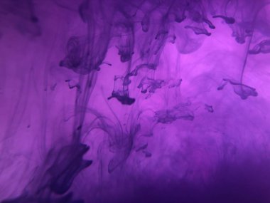 Suda mürekkep bulunan soyut pembe arkaplan.