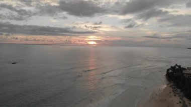 Güneşin doğuşuyla birlikte Sri Lanka 'da güzel sıcak bir günde kumsalda havadan yükselme. Drone videosu