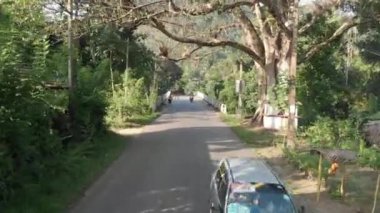 Sri Lanka. Köprünün üzerinde bir uçuş. Bir motosikletli geçiyor.. 