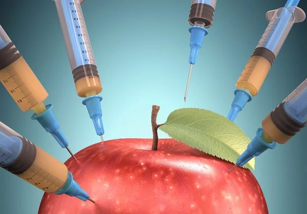 Syringe taking the juice from apple — Stock Photo, Image