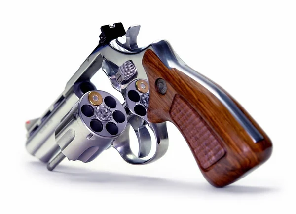 An old metal pistol with a drum on a wooden table.Russian roulette. A  revolver . Stock Photo