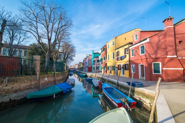 Bunt bemalte Häuser mit Spiegelungen im Wasser auf Burano und Boote im Kanal — Stockfoto