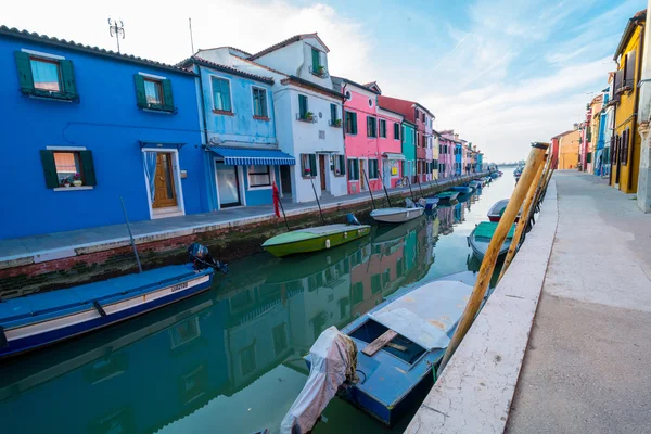 Burano su yansımalar ve kanal tekneleri ile rengarenk boyalı evleri