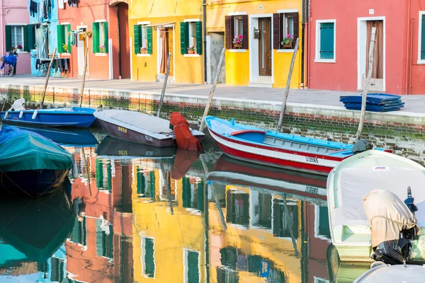 Burano su yansımalar ve kanal tekneleri ile rengarenk boyalı evleri